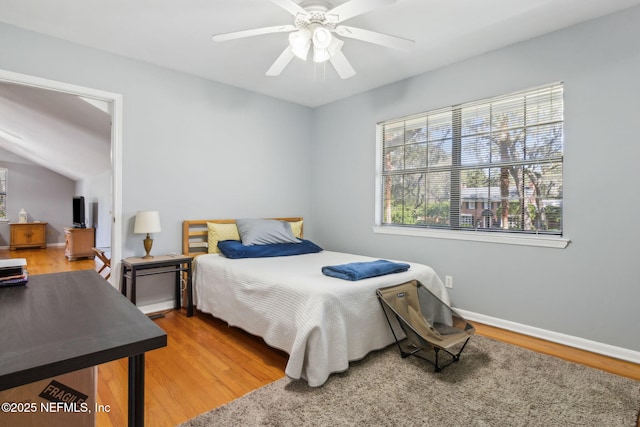 bedroom featuring baseboards, light wood-style flooring, and a ceiling fan