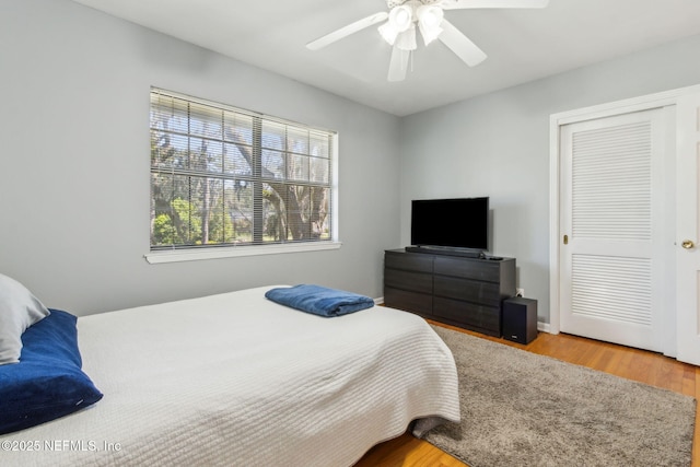 bedroom with wood finished floors, a closet, and ceiling fan