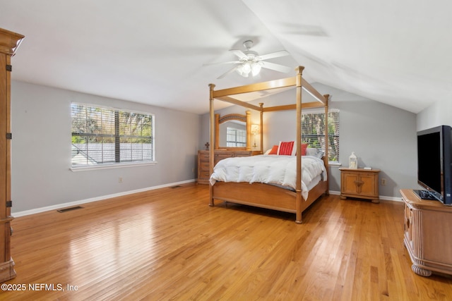 bedroom with light wood-type flooring, visible vents, multiple windows, and vaulted ceiling