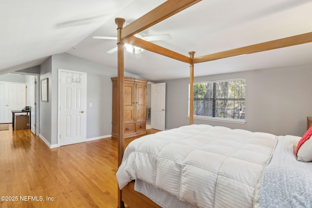 bedroom with light wood-type flooring, lofted ceiling, baseboards, and ceiling fan