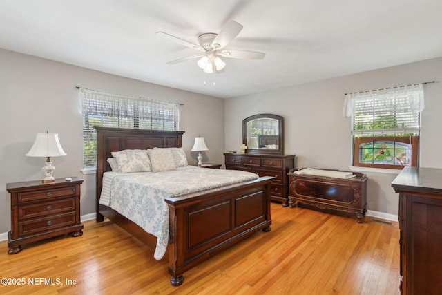 bedroom featuring a ceiling fan, light wood-style floors, and baseboards