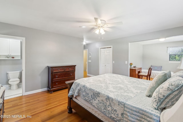 bedroom with connected bathroom, baseboards, light wood-style floors, a closet, and a ceiling fan