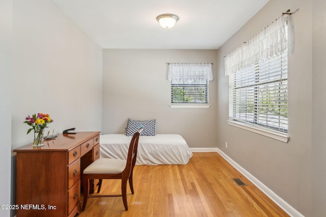 sitting room with baseboards, visible vents, and light wood finished floors