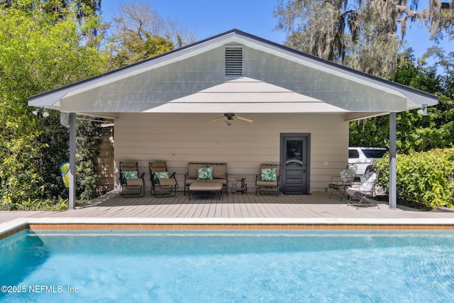 outdoor pool with a ceiling fan and a wooden deck