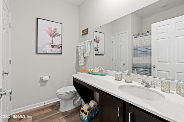 full bathroom featuring toilet, vanity, wood finished floors, a shower with curtain, and baseboards