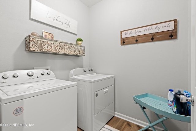 washroom with laundry area, baseboards, washer and dryer, and wood finished floors