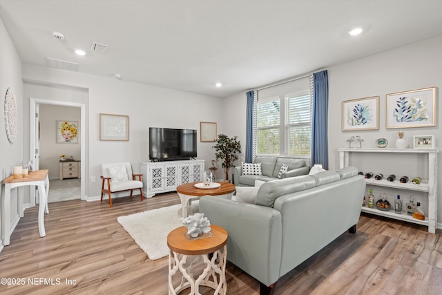 living area with light wood-style flooring, visible vents, and recessed lighting