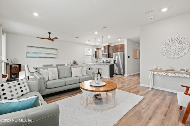 living area with ceiling fan, light wood-style flooring, recessed lighting, visible vents, and baseboards