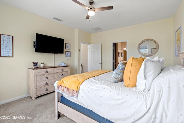 bedroom with visible vents, a ceiling fan, light carpet, ensuite bath, and baseboards