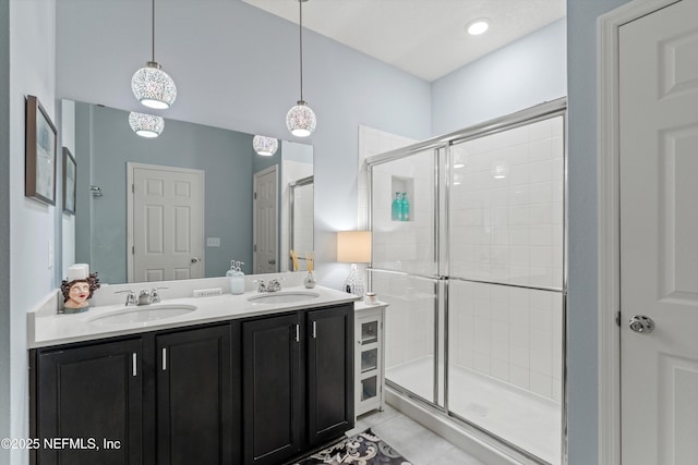 full bath featuring tile patterned floors, a sink, a shower stall, and double vanity