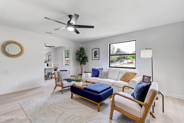 living area with a ceiling fan, light wood-type flooring, visible vents, and baseboards