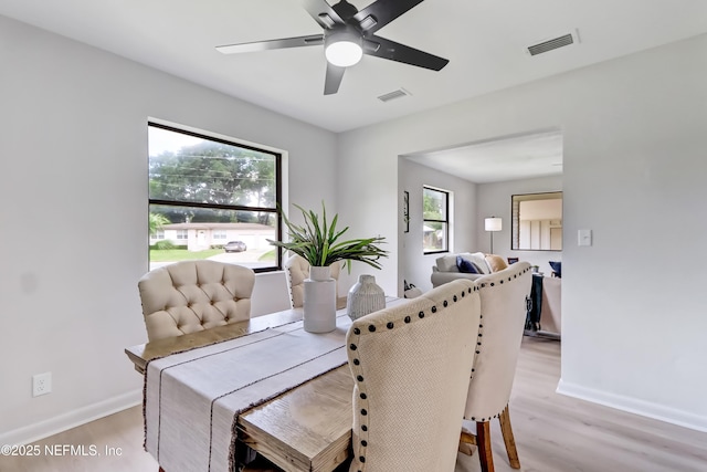 dining area featuring visible vents, light wood-style flooring, and baseboards