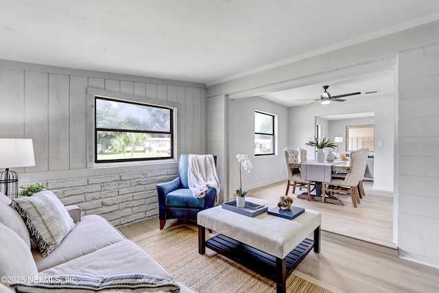 living area featuring light wood-type flooring, plenty of natural light, and baseboards