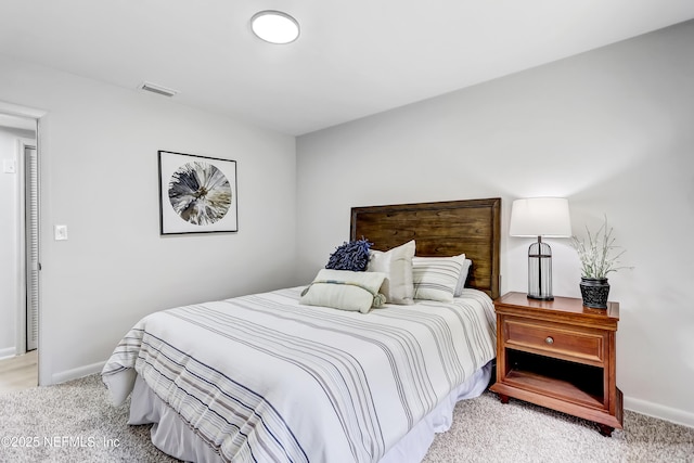 bedroom featuring visible vents, light carpet, and baseboards