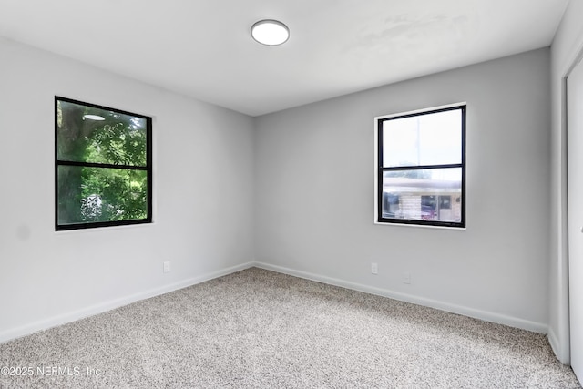 spare room featuring carpet and baseboards