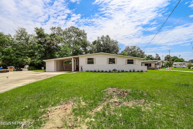 ranch-style home with a front lawn, an attached carport, concrete driveway, and brick siding