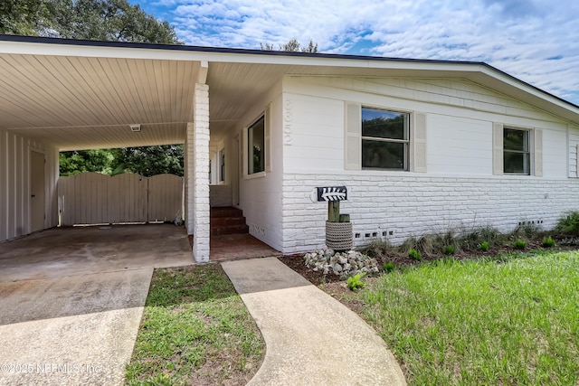 view of front of house featuring crawl space, an attached carport, and concrete driveway