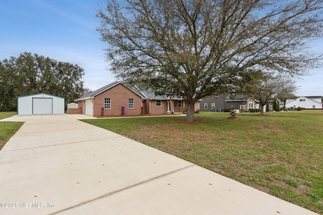 ranch-style house featuring concrete driveway, a detached garage, an outdoor structure, a front lawn, and brick siding