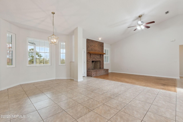 unfurnished living room featuring lofted ceiling, light tile patterned floors, a fireplace, and visible vents