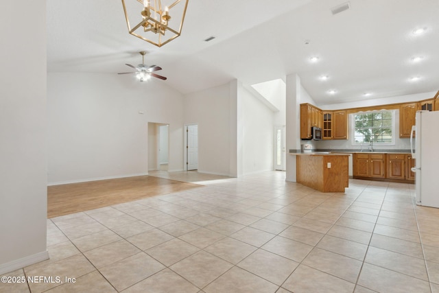 kitchen with open floor plan, light tile patterned floors, visible vents, and freestanding refrigerator