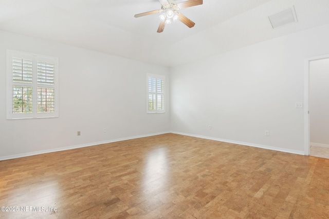 empty room featuring ceiling fan, baseboards, visible vents, and light wood-style flooring