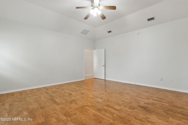 spare room featuring light wood finished floors, baseboards, visible vents, and a ceiling fan