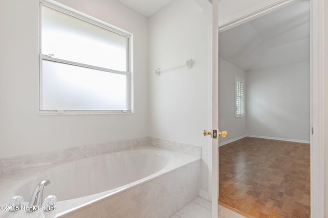 full bath with a garden tub and tile patterned floors