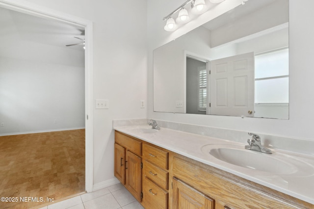 full bath featuring double vanity, baseboards, a sink, and tile patterned floors