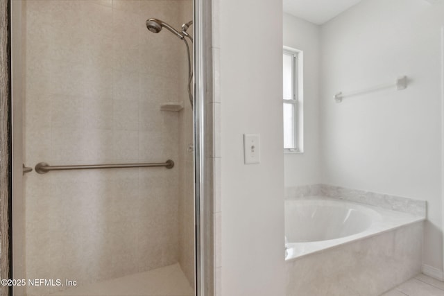 bathroom with a stall shower and a garden tub