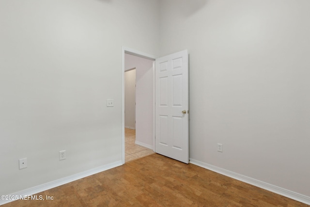 unfurnished room with light wood-type flooring and baseboards