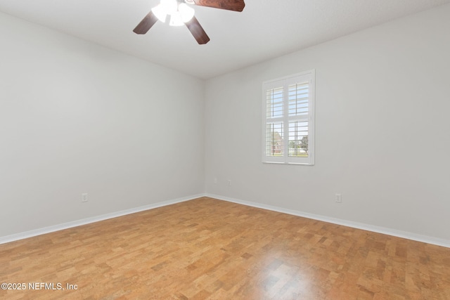 spare room featuring light wood-style flooring, baseboards, and ceiling fan