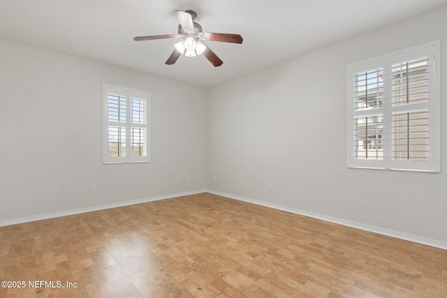 spare room featuring baseboards and a ceiling fan