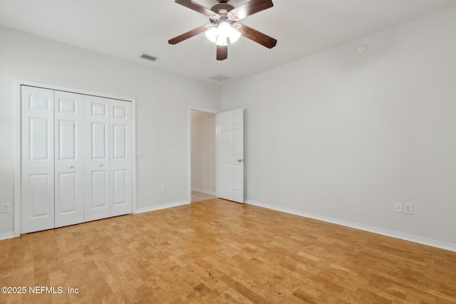 unfurnished bedroom with light wood-type flooring, a closet, visible vents, and baseboards