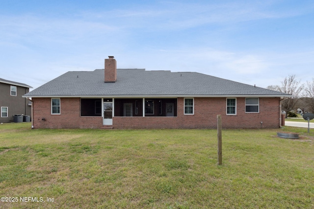 rear view of property featuring a yard, brick siding, a chimney, and roof with shingles