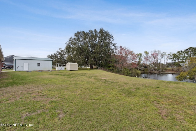 view of yard featuring a water view and an outdoor structure