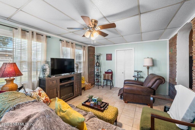 living room featuring light tile patterned floors, a paneled ceiling, and ceiling fan