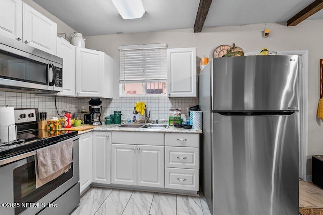 kitchen with beamed ceiling, marble finish floor, a sink, tasteful backsplash, and appliances with stainless steel finishes