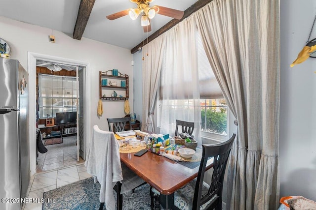 dining space with beam ceiling, marble finish floor, and a ceiling fan