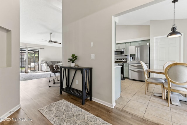 interior space with vaulted ceiling, light wood-style flooring, and baseboards