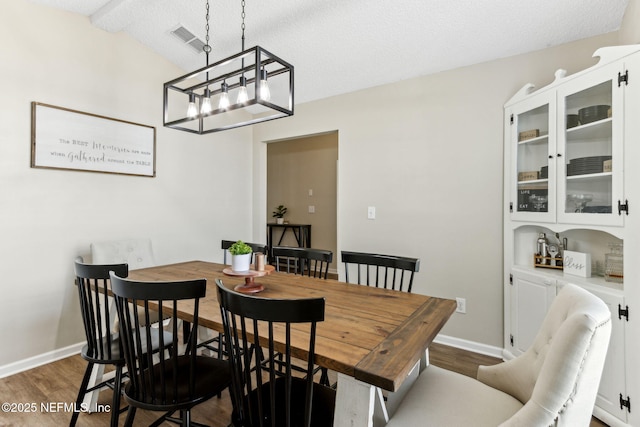 dining room featuring wood finished floors, visible vents, and baseboards