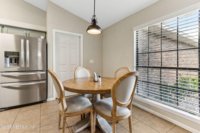 dining room featuring light tile patterned floors, baseboards, and lofted ceiling