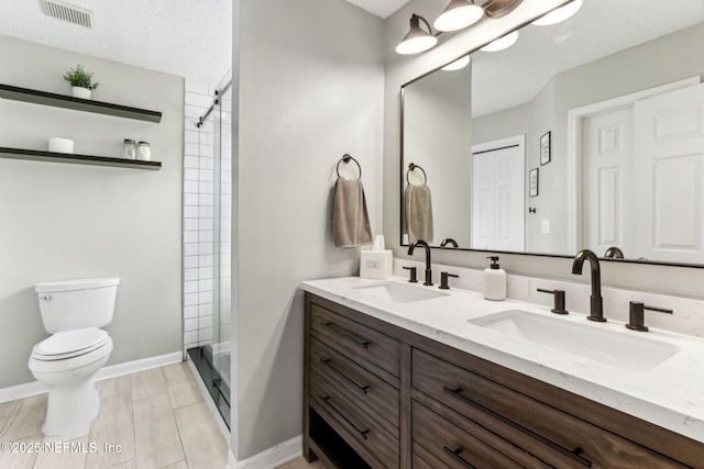 full bath with double vanity, visible vents, toilet, and a sink