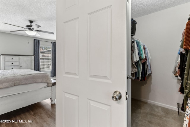 bedroom featuring baseboards, a textured ceiling, wood finished floors, and a ceiling fan