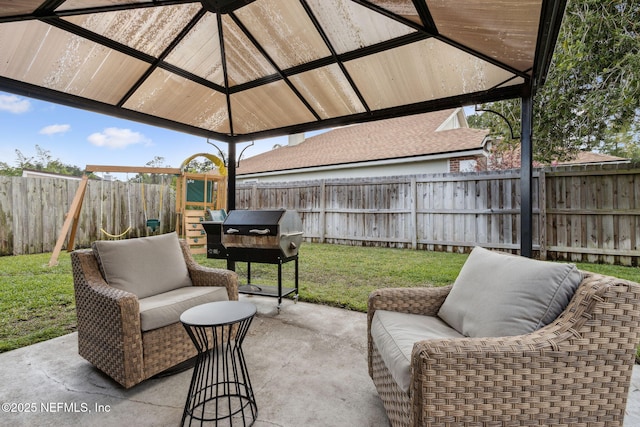 view of patio featuring an outdoor hangout area, a grill, a fenced backyard, and a playground