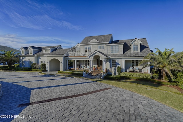 shingle-style home with a porch and a balcony