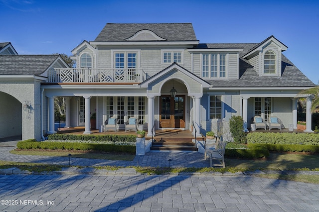 view of front of property featuring french doors, roof with shingles, and a porch