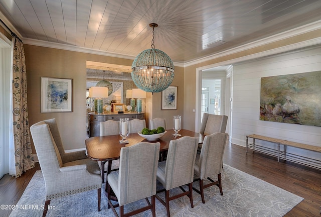 dining room featuring a chandelier, ornamental molding, and wood finished floors