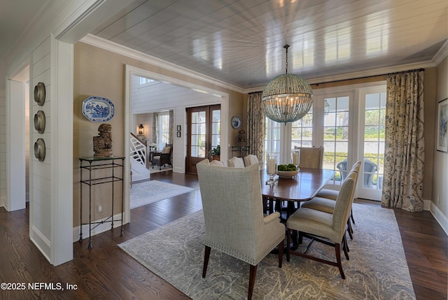 dining area featuring ornamental molding, dark wood-style flooring, baseboards, a chandelier, and stairs