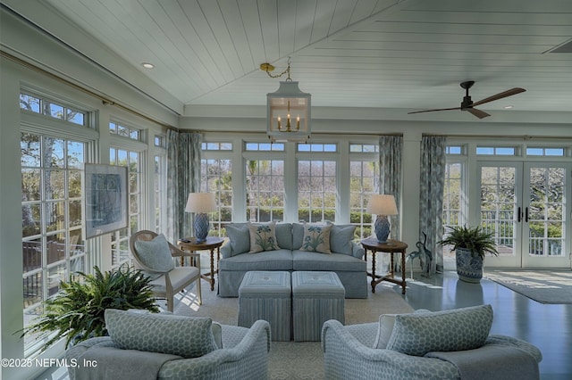 sunroom featuring ceiling fan with notable chandelier, wooden ceiling, and lofted ceiling