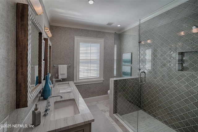 full bathroom with double vanity, toilet, crown molding, and a sink